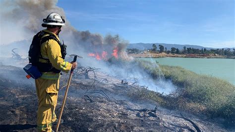 Crews work to contain grass fire at San Jose lake